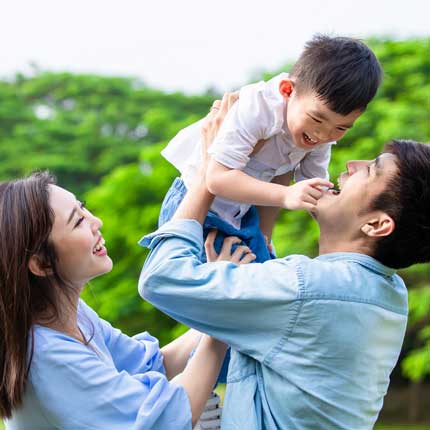 image of a happy couple with a little boy in a park.