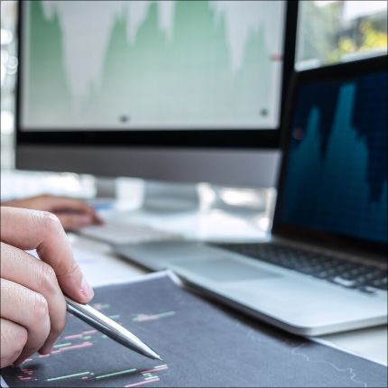 Image of 2 computers and someone taking notes - cash management